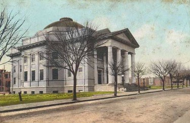 A drawing of a gray temple with a dome and columns out front.